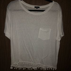 white tshirt with pom poms on the bottom